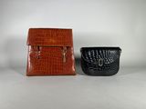 two brown and black purses sitting next to each other
