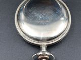 an old silver pocket watch sitting on top of a black table