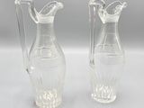 une paire de vases en verre transparent posés sur une table blanche