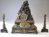 une statue représentant une femme assise au sommet d'une horloge, à côté de trois bougies