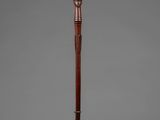 an old wooden stick with a wooden handle on a stand