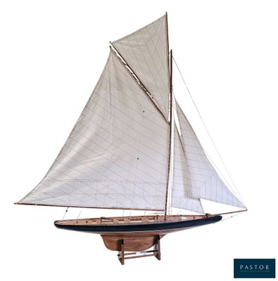 une maquette en bois d'un voilier avec une voile blanche