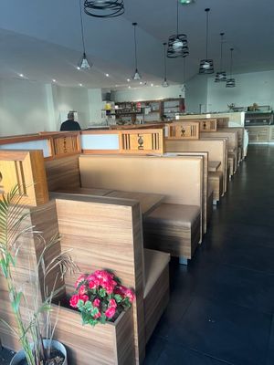 des tables et des bancs dans un restaurant, avec une plante en pot