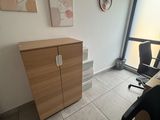 a desk with a chair and a cabinet in a room
