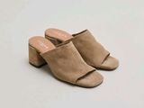 the woman is wearing a pair of mules that are made of sued
