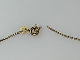 a close up of a gold chain with a clasp on a white surface