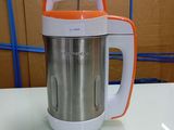 an orange and white blender sitting on a table