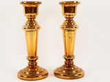 two golden candlesticks on a white background