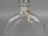 a clear glass bottle with a rope wrapped around it