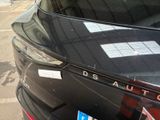 a black car parked in a parking lot with stickers on it