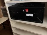 a black box sitting on top of a shelf in a closet