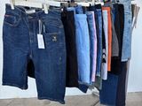 many pairs of jeans hanging on a rack in a room