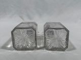 deux salières et poivrières en verre transparent posées sur une surface blanche