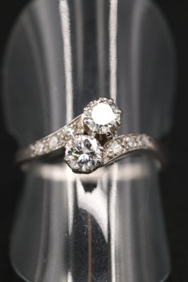 un gros plan d'une bague en diamant posée sur un présentoir en argent