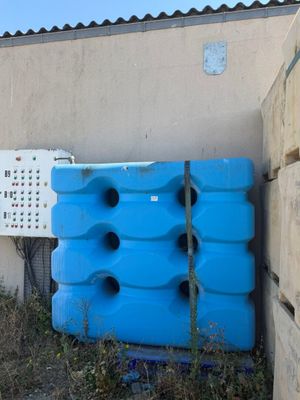 un grand conteneur bleu posé contre un mur