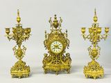 trois horloges dorées posées les unes à côté des autres sur une table