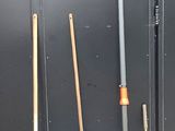 deux balais et un râteau devant la porte d'un garage