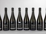 six bouteilles de vin sont alignées sur une table