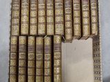 plusieurs vieux livres empilés les uns sur les autres dans une boîte en carton