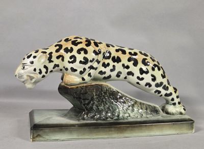figurine of a leopard on a rock on a white background