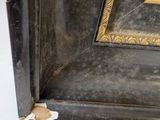the corner of a picture frame with peeling paint on it