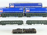 trois trains miniatures empilés les uns sur les autres sur une surface blanche