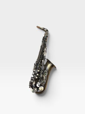 un gros plan d'un saxophone posé sur une surface blanche