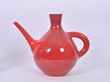 a red teapot sitting on a table with a white background