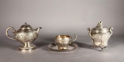 deux théières en argent et une tasse posée sur une soucoupe