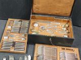 a lot of silverware in a wooden box on the floor