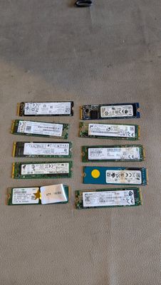 de nombreuses barrettes de mémoire vive posées par terre à côté d'un ordinateur portable