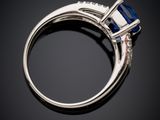 a blue sapphire and diamond ring on a black background