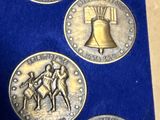 trois pièces d'argent surmontées d'une clochette, dans une boîte bleue