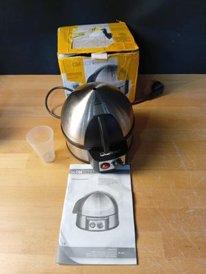 une cafetière posée sur une table en bois, à côté d'une boîte de café