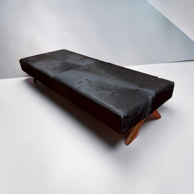 a black bench that is sitting on a white surface