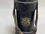 a black vase with a handle on a white table