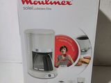 La boîte de la cafetière est ouverte sur la table.