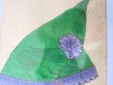 un chapeau vert orné d'une fleur, dessiné sur une feuille de papier