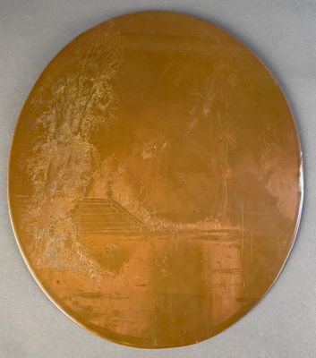 une assiette en or sur laquelle est représentée une maison