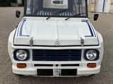 a white truck with blue stripes parked in front of a building