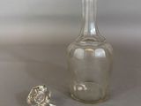 a glass bottle and a glass stopper on a table