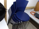 une pile de chaises bleues alignées les unes à côté des autres