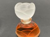 a small bottle of perfume with a flower on top of it