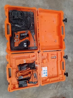 une mallette orange contenant des outils, posée sur un sol en béton