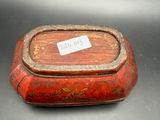 a small red box with writing on it on a table