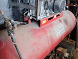 a red air compressor sitting on top of a red tank