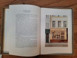 an open book sitting on top of a wooden table next to a window