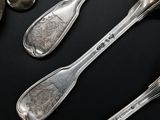five spoons and two spoons sitting on a table