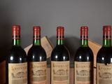 four bottles of red wine are lined up on a table