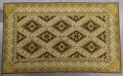 un gros plan d'un tapis marron et doré posé sur une surface blanche